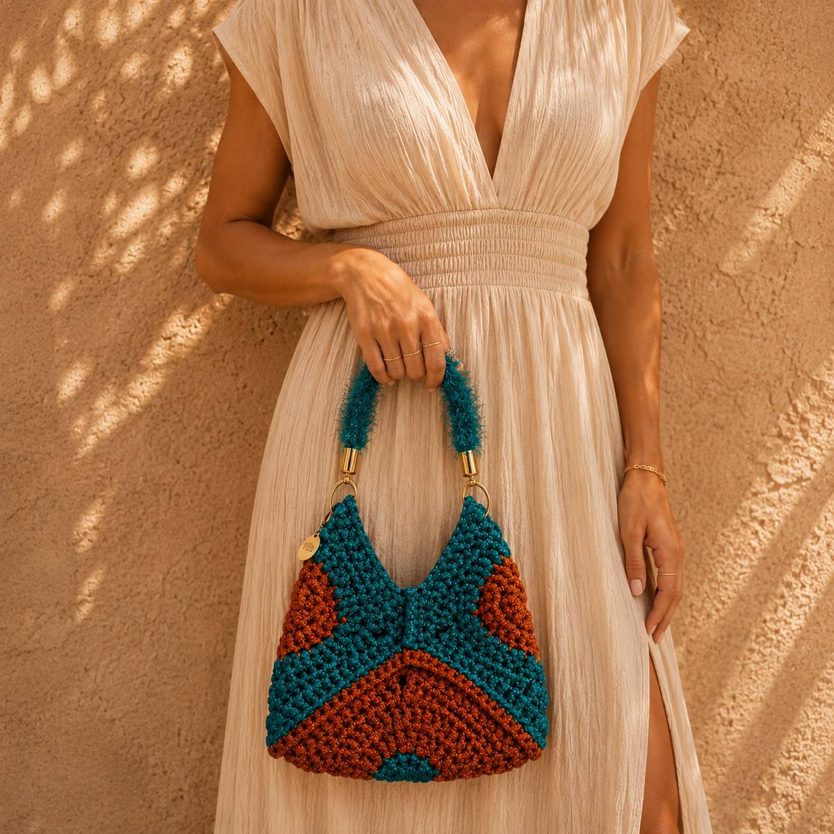 Handgemaakte clutch tas uit de Atelier Collection van Madrista, uitgevoerd in blauw met oranje, zachte handgreep en goudkleurige details.