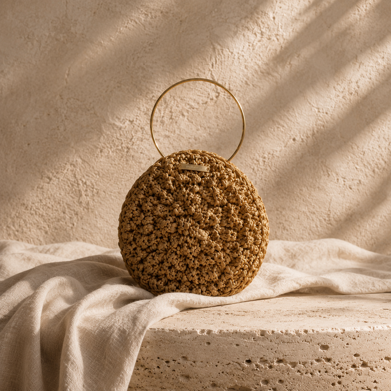 Handgemaakte satijnen clutch van Madrista met goudkleurig rond handvat uit de Atelier Collection.